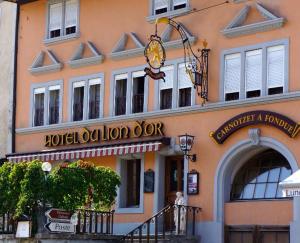 un edificio con un letrero de hotel abierto en él en Hôtel Lion d'Or Romont en Romont