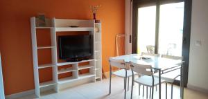 Zimmer mit einem Tisch und einem TV sowie einem Tisch und Stühlen in der Unterkunft Apartaments del Llierca in Sant Jaume de Llierca