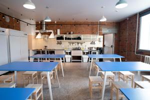 a room with blue tables and chairs and a kitchen at Strawberry Duck St. Petersburg in Saint Petersburg