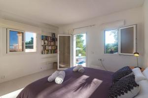 Schlafzimmer mit einem großen lila Bett und Fenstern in der Unterkunft Villa Casiopea in Ibiza-Stadt