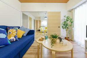 uma sala de estar com um sofá azul e uma mesa em 札幌市中心部大通公園まで徒歩十分観光移動に便利なロケーションh207 em Sapporo