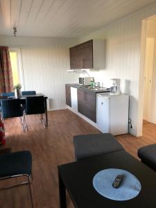 - un salon avec une cuisine et une table avec télécommande dans l'établissement Aktivitetsbyen Gamle Fredrikstad, à Fredrikstad