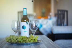 two wine glasses and a plate of grapes on a table at BLUE SEA apartment in Torrevieja