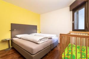 1 Schlafzimmer mit 2 Betten und gelben Wänden in der Unterkunft Apartment Goethe 1 in Bozen
