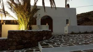 uma casa branca com uma palmeira em frente em RADYSHAMS DAMMUSI LE PALME & BAIT em Pantelleria