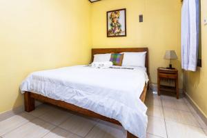 
a bed in a room with a white bedspread at Dekwah Homestay in Ubud

