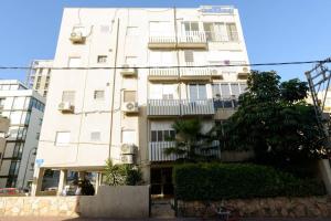 d'un grand bâtiment blanc avec balcon. dans l'établissement Botiuqe apartment . 100 meters from the beach, à Tel Aviv