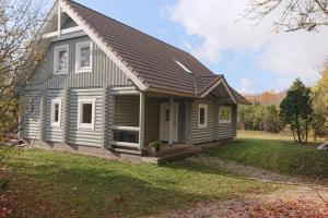 a small wooden house with a porch on a yard at Captain Alexandri Cottage by the Sea in Kõiguste