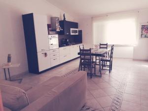 a living room with a couch and a table and a kitchen at Deluxe House of Loto's in Fiumicino +4 photos