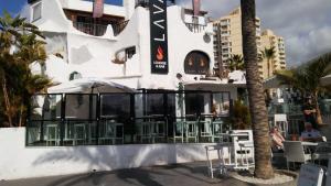 a building with tables and chairs in front of it at Casas Blancas Las Tortugas in Playa de las Americas