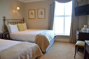 Voodi või voodid majutusasutuse The Listowel Arms Hotel toas