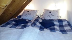 a bed with blue and white sheets and pillows at Ferienwohnung Auf Schäfers Spuren in Buergstadt
