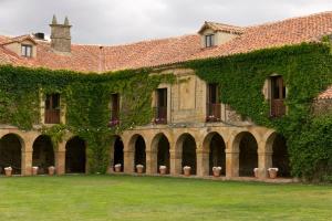 an ivy covered building with a green yard at Casa rural Casa Fuerte San Gregorio I in Almarza