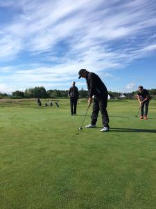 un grupo de personas jugando al golf en un campo de golf en Aktivitetsbyen Gamle Fredrikstad en Fredrikstad