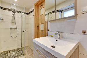 a bathroom with a sink and a shower at Villa Arkodes in Gdańsk