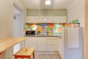 a kitchen with white cabinets and a refrigerator at Villa Arkodes in Gdańsk