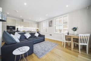 a living room with a couch and a dining room at Flat 1 Bridge House in Staines