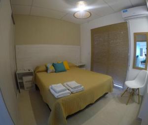 Un dormitorio con una cama con toallas. en C1 Suite, en Las Varillas