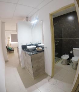 Un baño con lavabo, inodoro y espejo. en C1 Suite, en Las Varillas
