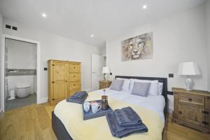 1 dormitorio con 1 cama grande y toallas. en Flat 1 Bridge House, en Staines