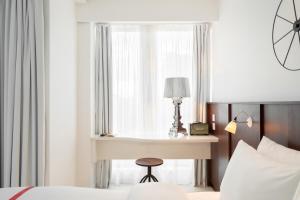 um quarto com uma secretária, uma cama e uma janela em Ruby Lucy Hotel London em Londres