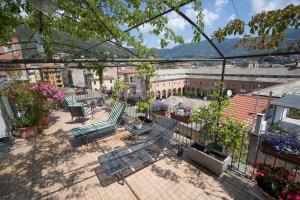 - un balcon avec des bancs, des tables et des fleurs dans l'établissement Hotel Nazionale, à Levanto