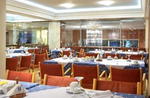 une salle à manger avec des tables, des chaises et un chiffon bleu dans l'établissement Hotel Samaras, à Lamía