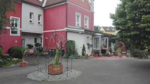 einen Innenhof eines roten und weißen Hauses mit einer Pflanze in der Unterkunft Ferienwohnung Murtal in Sankt Lorenzen bei Knittelfeld