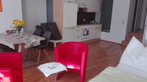 salon z czerwonym krzesłem i stołem w obiekcie Ferienwohnung Murtal w mieście Sankt Lorenzen bei Knittelfeld