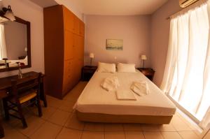 a bedroom with a bed and a desk and a mirror at Ithaki Holidays in Lefkada +77 photos