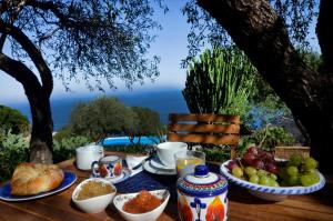 uma mesa com pequeno almoço de pão e frutas em Baglio La Luna - B&B em San Vito lo Capo