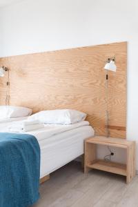 ein Schlafzimmer mit einem Bett, einer Lampe und einem Tisch in der Unterkunft Smiltynės Jachtklubas in Klaipėda