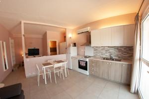 a kitchen with white appliances and a table with chairs at Ithaki Holidays in Lefkada
