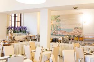 レヴァントにあるHotel Nazionaleのダイニングルーム(白いテーブル、椅子付)