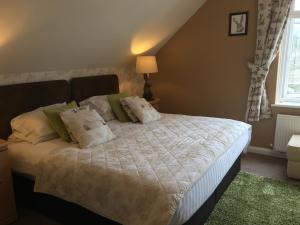 a bedroom with a bed with white sheets and pillows at Earlston House in Paignton