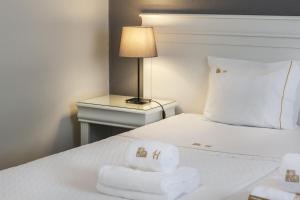 a white bed with a white comforter and pillows at Hotel Gaivota Azores in Ponta Delgada