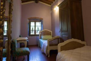 1 dormitorio con 2 camas, silla y espejo en Agriturismo Casariccio - Casa Viola, en Bucine