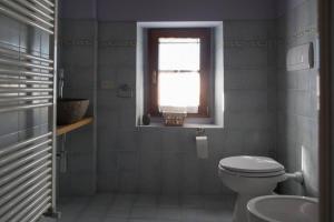 baño con aseo y lavabo y ventana en Agriturismo Casariccio - Casa Viola, en Bucine