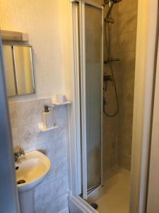 un baño con ducha y lavabo en Beachcomber Guesthouse, en Weymouth 139 fotos más