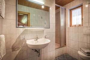 łazienka z umywalką, lustrem i toaletą w obiekcie Haus Ausserstein w mieście Finkenberg +6 zdjęć