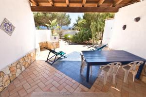 un patio con mesa negra y sillas en Villa Saba, en Lampedusa