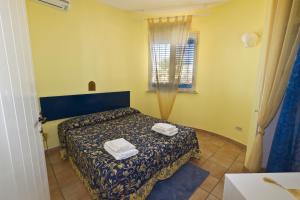 - une chambre avec un lit et 2 serviettes dans l'établissement Villa Saba, à Lampedusa