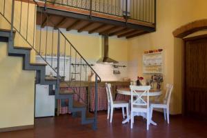 una cocina con mesa y sillas y una escalera en Agriturismo Casariccio - Casa Dalia, en Bucine
