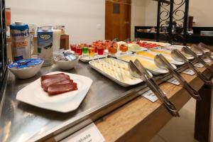 un buffet con diferentes tipos de comida en un mostrador en Hotel Amsterdam Montes Claros, en Montes Claros