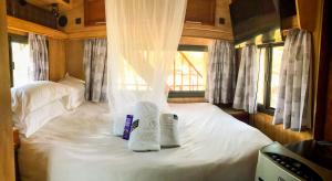 a bedroom with two beds with towels on it at Maggie May House Boat - Colchester - 5km from Elephant Park in Colchester