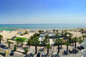z góry widok na plażę z samochodami i palmami w obiekcie Appartamento Calipso - MyHo Casa w mieście Tortoreto Lido