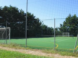 a fence on a tennis court with a net at Fattoria La Steccaia in Riparbella