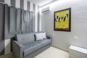 a living room with a couch and a painting at Foresteria Lombarda GELSO BIANCO in Cogliate +13 photos