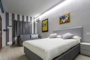 a bedroom with a large bed and a chair at Foresteria Lombarda GELSO BIANCO in Cogliate