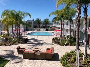 a resort with a pool and palm trees at Melbourne All Suites Inn near I95 in Melbourne